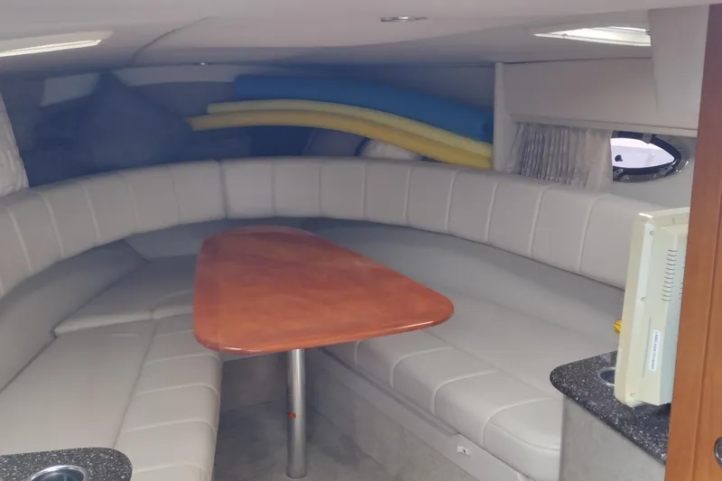 Slide: The Image of Interior of 2005 Formula 330 Sun Sport boat with curved seating and wooden table. - 26