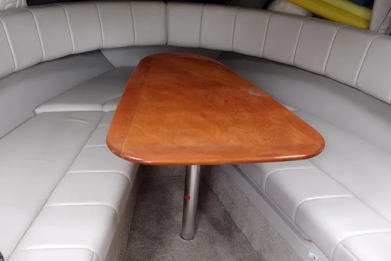 Slide: The Image of Interior of 2005 Formula 330 Sun Sport boat with wooden table and cushioned seating. - 27
