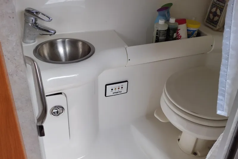 Slide: The Image of 2005 Formula 330 Sun Sport boat bathroom with sink, toilet, and cleaning supplies. - 29