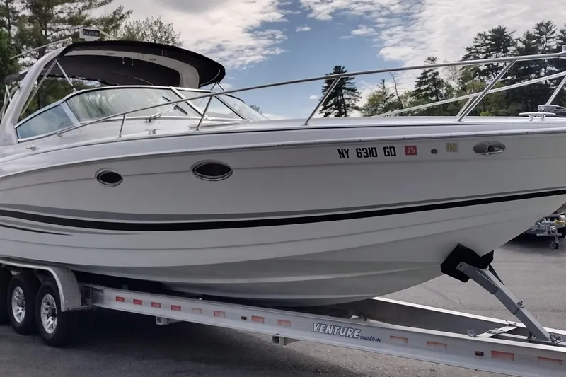 Slide: The Image of 2005 Formula 330 Sun Sport boat on trailer, parked outdoors under a partly cloudy sky. - 3