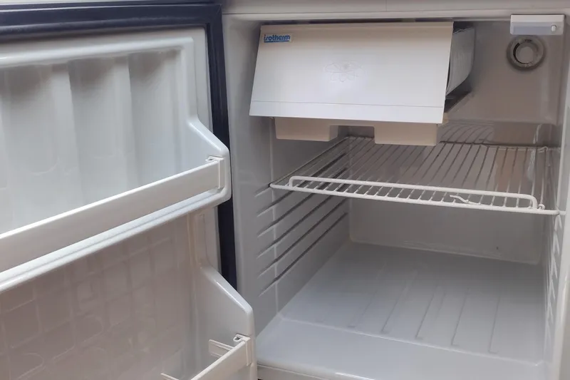 Slide: The Image of Empty refrigerator interior with wire shelf and door storage compartments. - 37