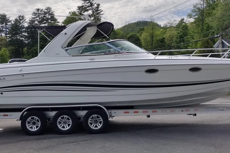Slide: The Image of 2005 Formula 330 Sun Sport boat on trailer, surrounded by trees and cloudy sky. - 4