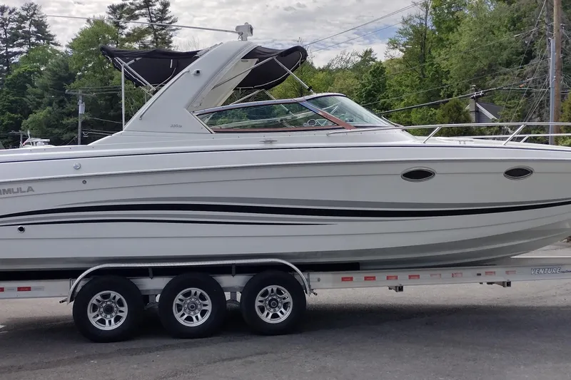 Slide: The Image of 2005 Formula 330 Sun Sport boat on trailer, parked outdoors with trees in background. - 5