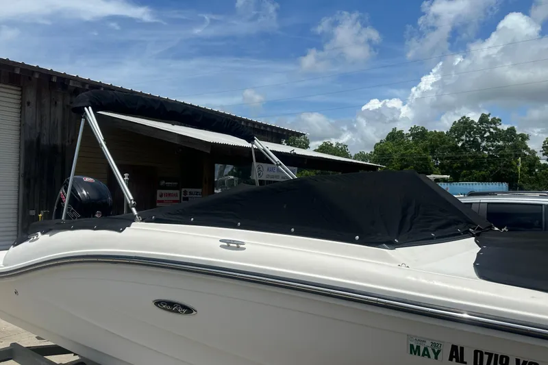 Slide: The Image of 2017 Sea Ray SPX 190 Outboard boat with black cover, parked outdoors under blue sky. - 10