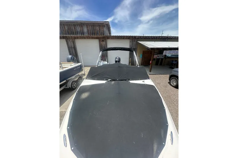 Slide: The Image of 2017 Sea Ray SPX 190 Outboard boat with cover, parked outdoors under a blue sky. - 11