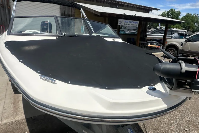Slide: The Image of 2017 Sea Ray SPX 190 Outboard boat with black cover, parked at a marina. - 7