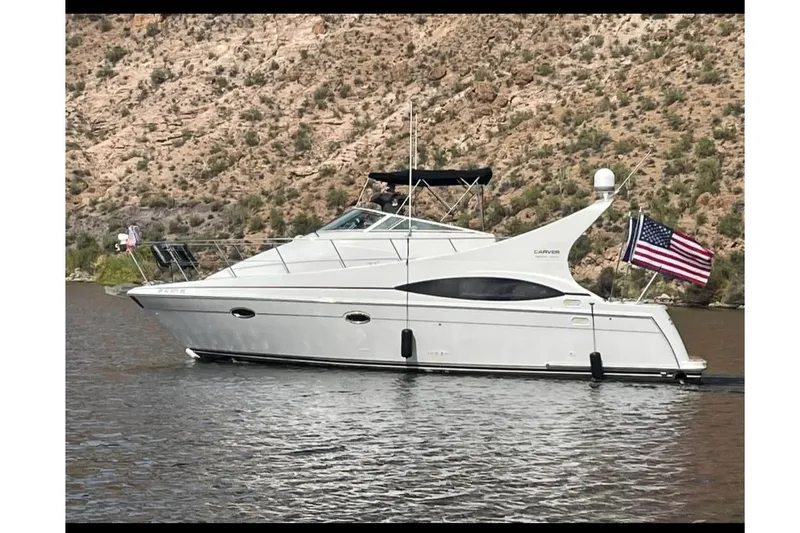 The Image of 2001 Carver 350 Mariner yacht on a scenic lake with American flag. - 0