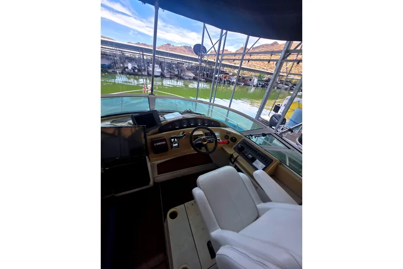 Slide: The Image of Interior view of 2001 Carver 350 Mariner yacht helm with marina backdrop. - 11