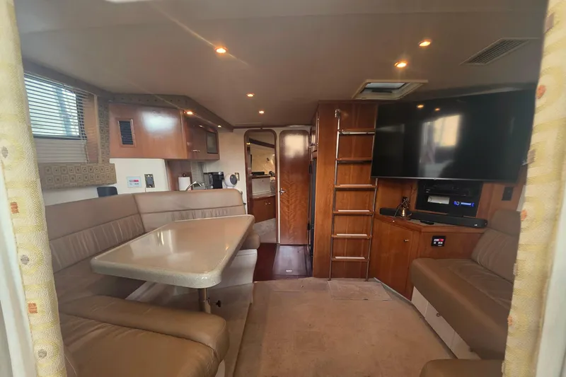 Slide: The Image of Interior of 2001 Carver 350 Mariner yacht with seating, table, and entertainment system. - 13