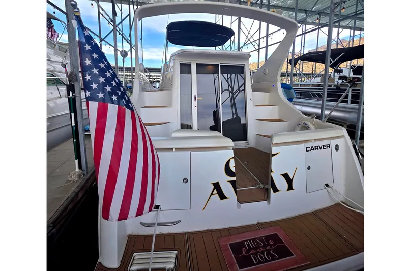 Slide: The Image of 2001 Carver 350 Mariner yacht with American flag, docked in marina. - 2