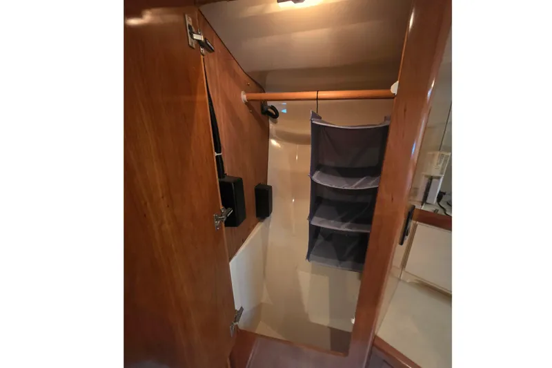 Slide: The Image of Interior of 2001 Carver 350 Mariner yacht, featuring a compact wooden storage area. - 29