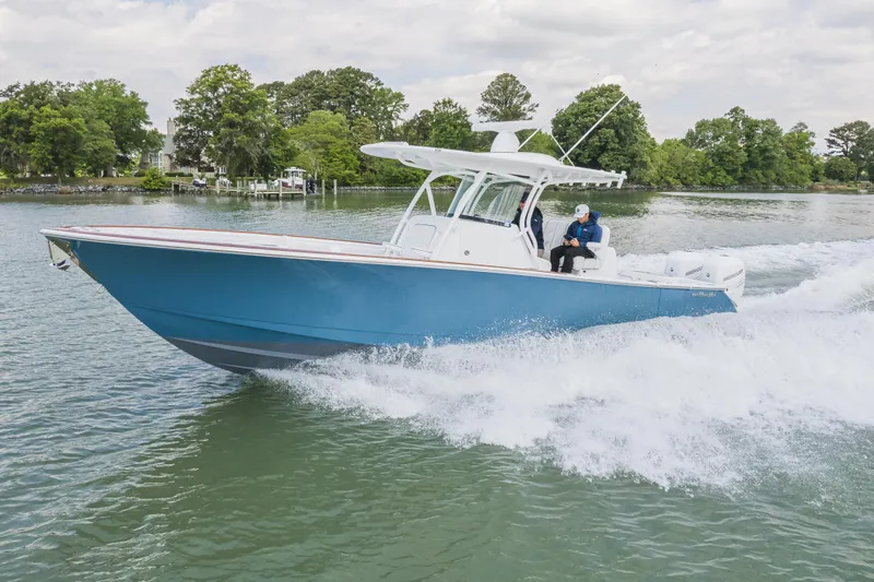 The Image of 2022 Valhalla Boatworks V-33 cruising on a scenic lake with lush greenery. - 0