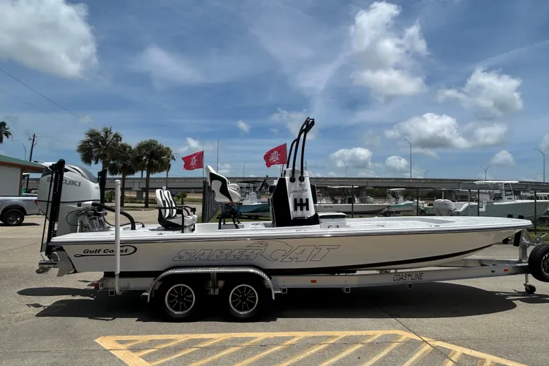 Slide: The Image of 2026 Gulf Coast Saber Cat 25 boat on trailer under blue sky. - 5