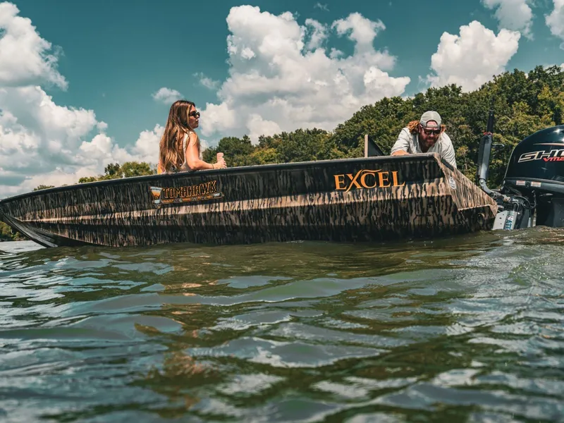 Slide: The Image of Excel Boats Tomahawk 183, 2026, on a lake with two people. - 11