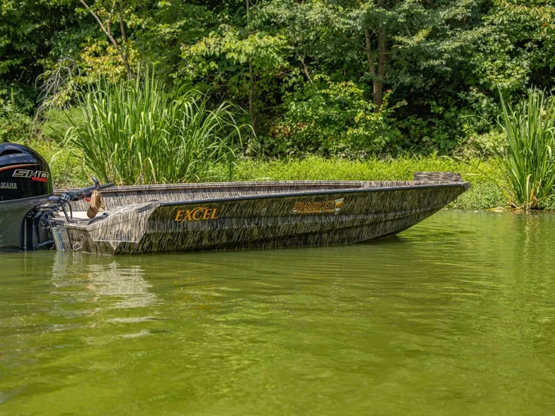 Slide: The Image of Excel Boats Tomahawk 183, 2026, on green water with lush forest backdrop. - 7