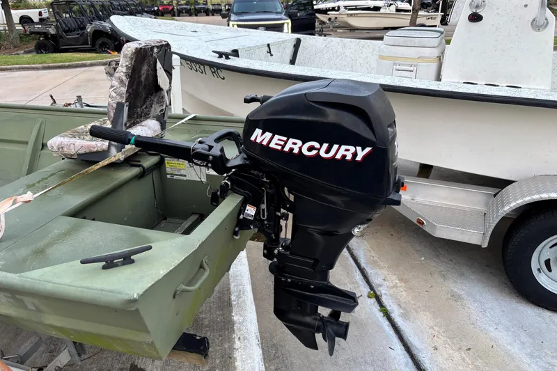 Slide: The Image of 2011 Alumacraft 1542 Jon boat with Mercury outboard motor, parked on a trailer. - 2