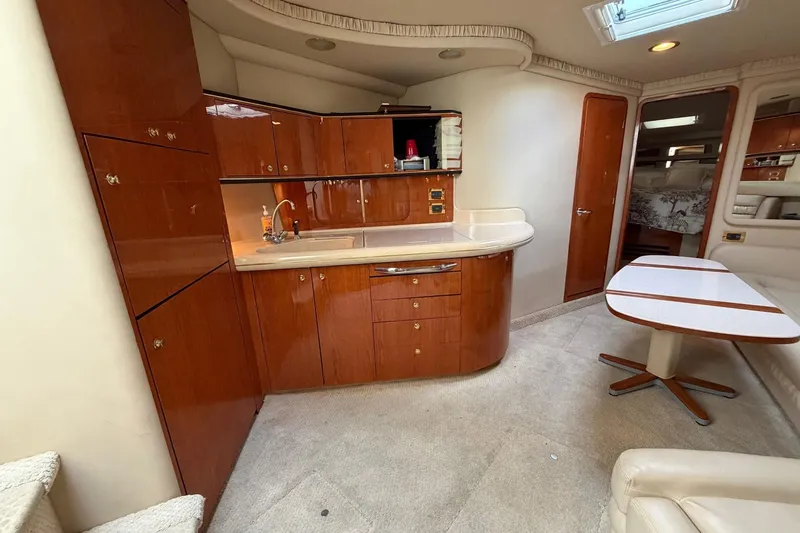 Slide: The Image of Interior of 2000 Sea Ray Sundancer 460 yacht with wooden cabinetry and dining area. - 26