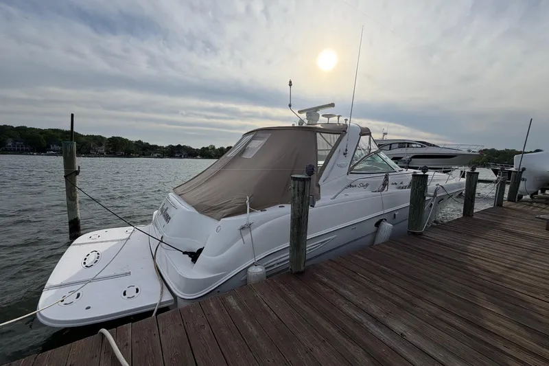 Slide: The Image of 2000 Sea Ray Sundancer 460 yacht docked at a wooden pier under a cloudy sky. - 3