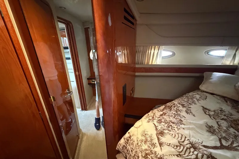Slide: The Image of Interior cabin of 2000 Sea Ray Sundancer 460 yacht, featuring wood paneling and cozy bedding. - 36