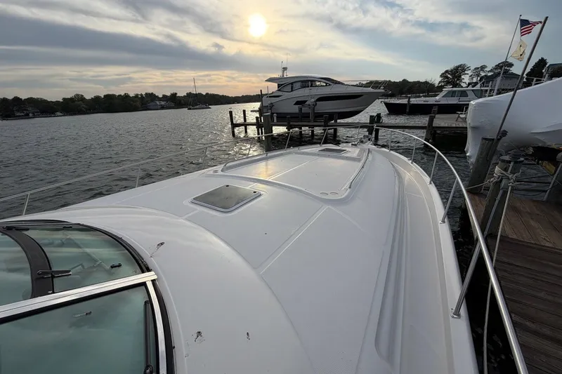 Slide: The Image of 2000 Sea Ray Sundancer 460 yacht docked at sunset, with calm waters and scenic background. - 4