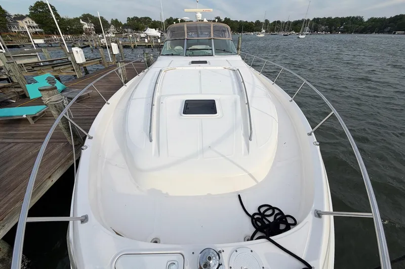 Slide: The Image of Front view of a 2000 Sea Ray Sundancer 460 yacht docked by the water. - 7