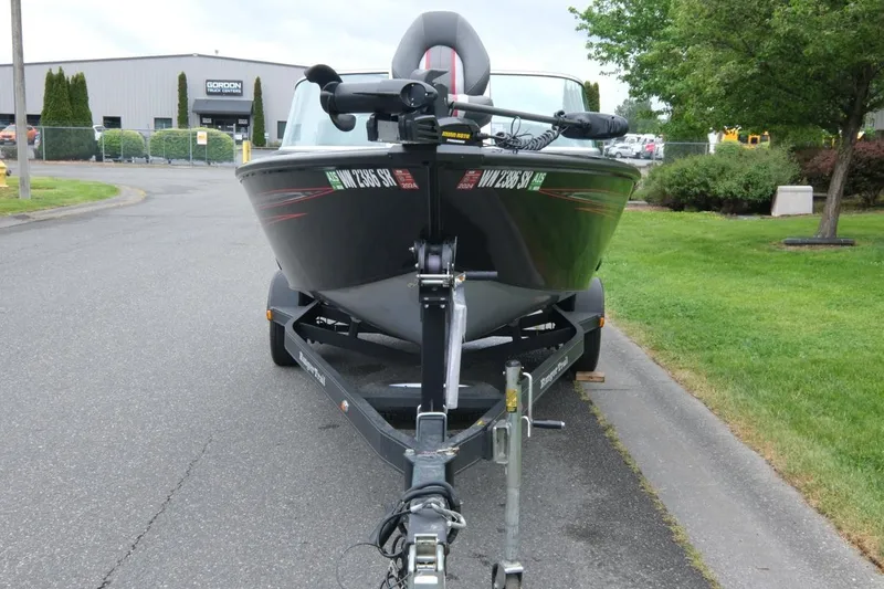 Slide: The Image of 2018 Ranger VS1670 WT boat on trailer, parked on roadside near greenery and industrial building. - 5