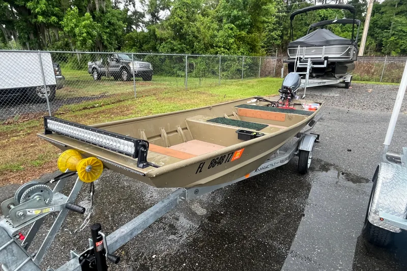 The Image of 2025 G3 Gator Tough 1436 boat on trailer, equipped with motor and light bar. - 1