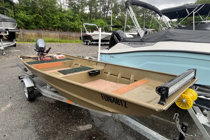 Slide: The Image of 2025 G3 Gator Tough 1436 boat on trailer, parked outdoors near other boats. - 3