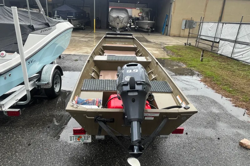 Slide: The Image of 2025 G3 Gator Tough 1436 boat with 9.9 HP motor, parked outdoors. - 8