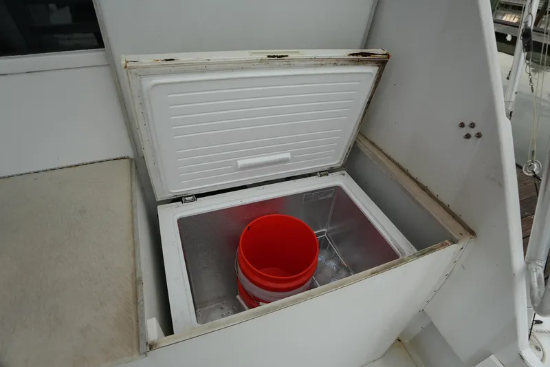 Slide: The Image of Open storage compartment on 1980 Hatteras 50 Convertible boat with red bucket inside. - 14