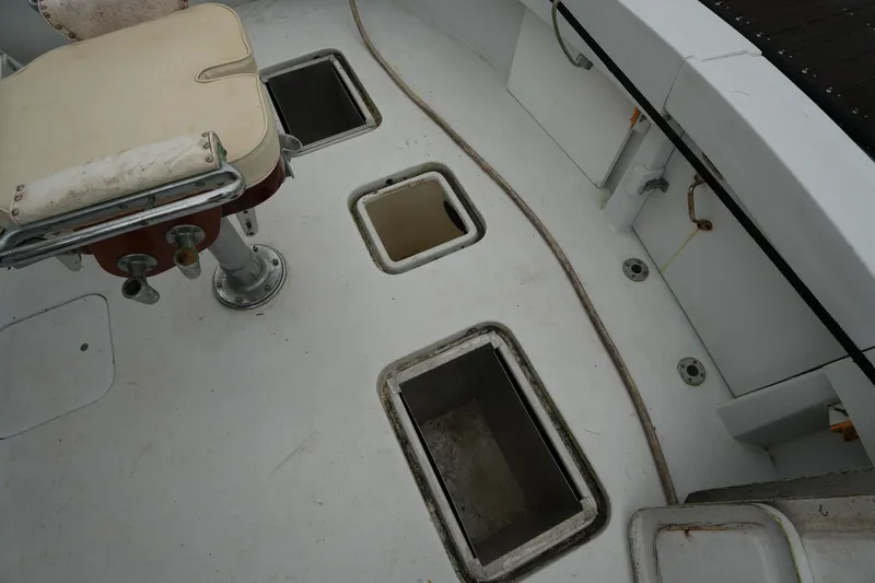 Slide: The Image of 1980 Hatteras 50 Convertible boat deck with fishing chair and storage compartments. - 15