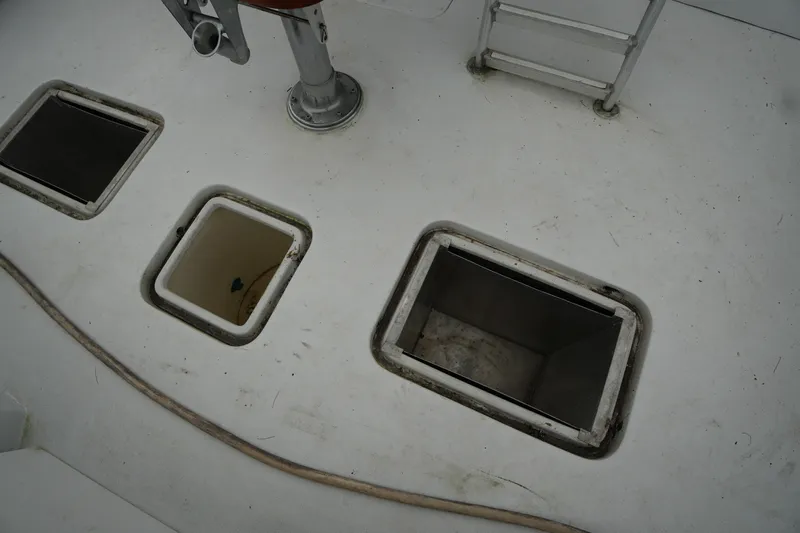 Slide: The Image of 1980 Hatteras 50 Convertible boat deck with open storage compartments and ladder. - 16