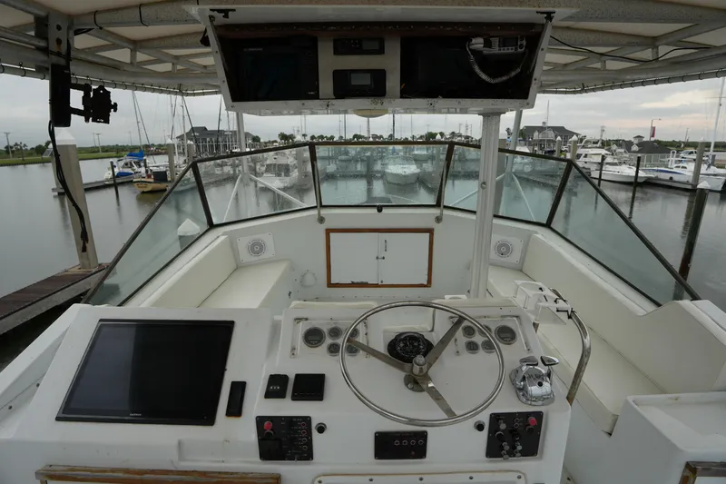 Slide: The Image of Cockpit view of a 1980 Hatteras 50 Convertible yacht at a marina. - 19