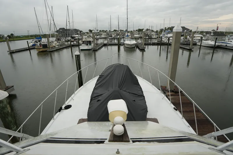 Slide: The Image of 1980 Hatteras 50 Convertible yacht docked in a marina, surrounded by sailboats. - 25