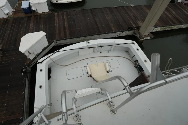 Slide: The Image of 1980 Hatteras 50 Convertible boat docked, view of spacious deck and seating area. - 26