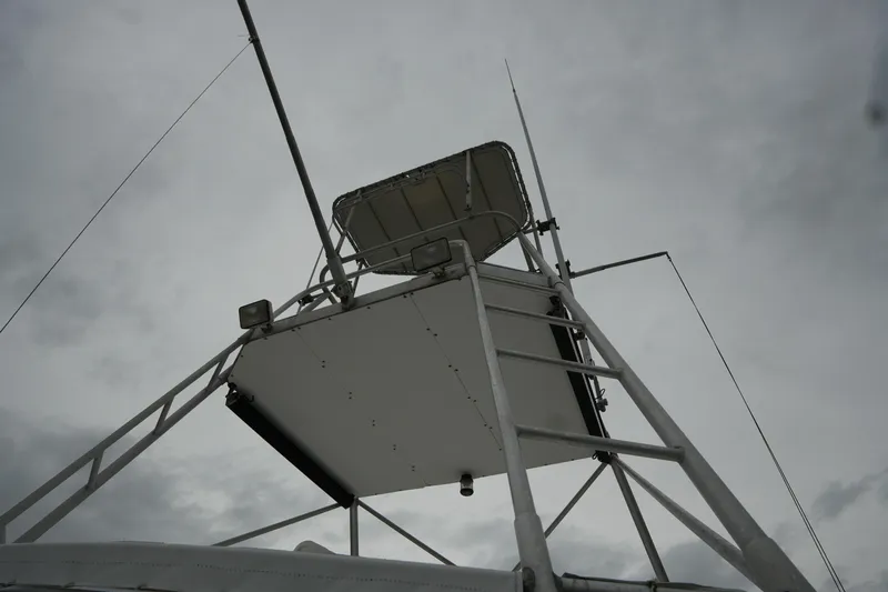 Slide: The Image of Antenna and ladder on 1980 Hatteras 50 Convertible yacht against cloudy sky. - 27