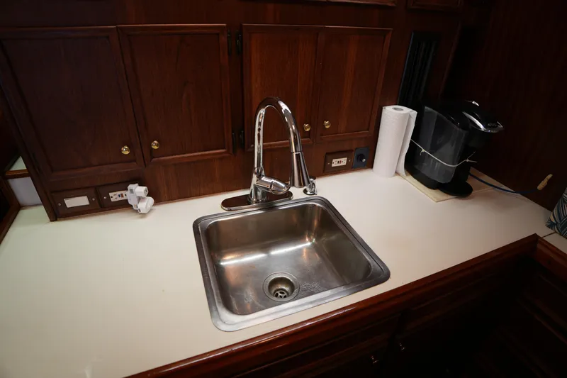 Slide: The Image of Kitchen sink area on a 1980 Hatteras 50 Convertible yacht with wooden cabinetry. - 37