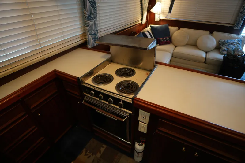 Slide: The Image of 1980 Hatteras 50 Convertible yacht kitchen with stove and cozy seating area. - 38