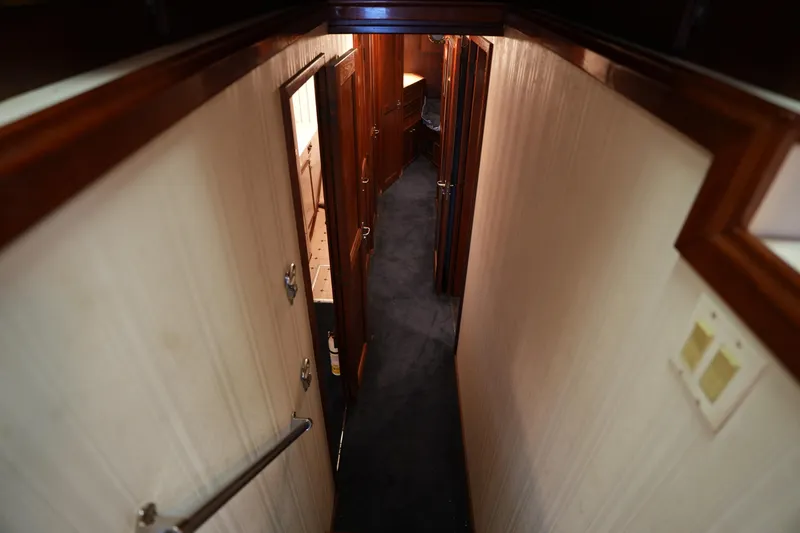 Slide: The Image of Narrow hallway inside 1980 Hatteras 50 Convertible yacht with wooden doors and carpeted floor. - 42