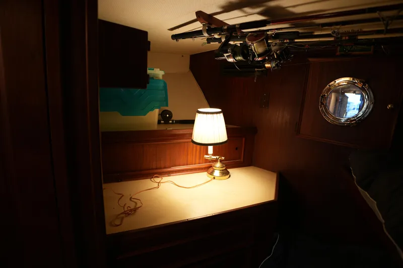 Slide: The Image of Cozy cabin interior of 1980 Hatteras 50 Convertible with lamp and fishing rods. - 44