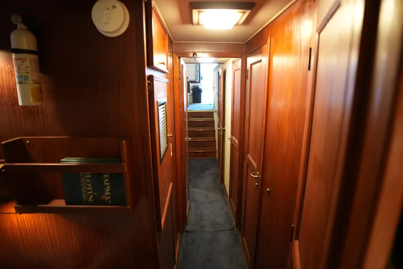 Slide: The Image of Interior hallway of 1980 Hatteras 50 Convertible yacht with wooden paneling and carpeted floor. - 45
