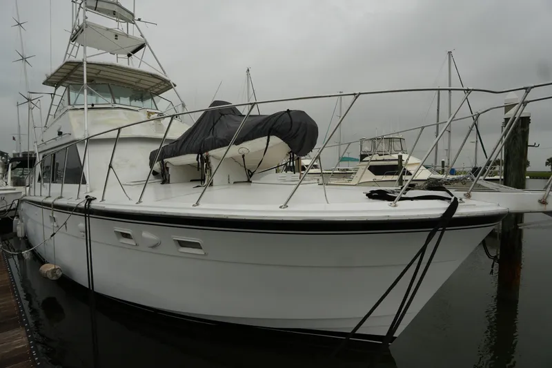 Slide: The Image of 1980 Hatteras 50 Convertible yacht docked at marina on a cloudy day. - 5