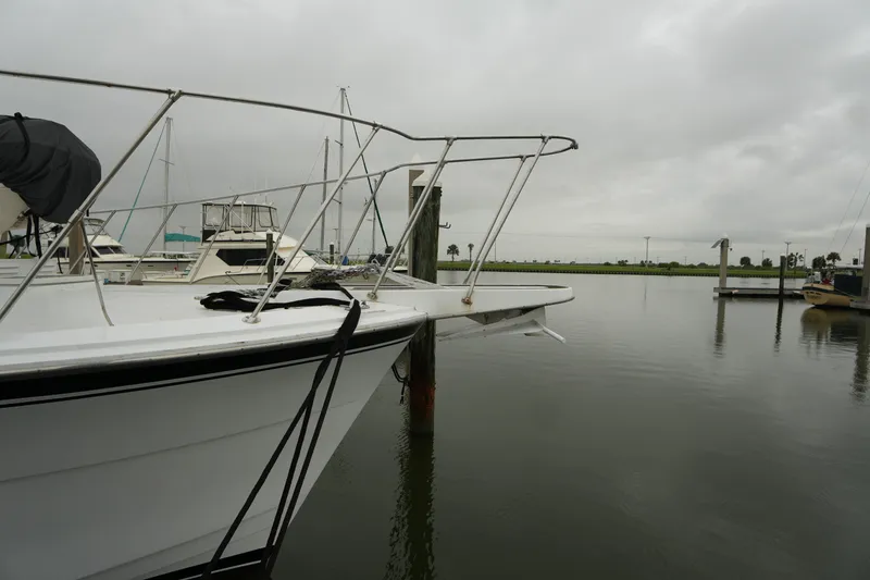 Slide: The Image of 1980 Hatteras 50 Convertible yacht docked in a marina on a cloudy day. - 6