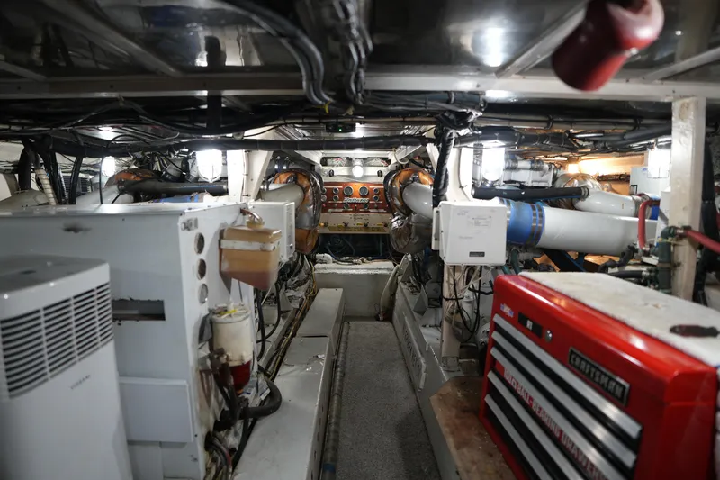 Slide: The Image of Engine room of a 1980 Hatteras 50 Convertible yacht, featuring machinery and tools. - 61