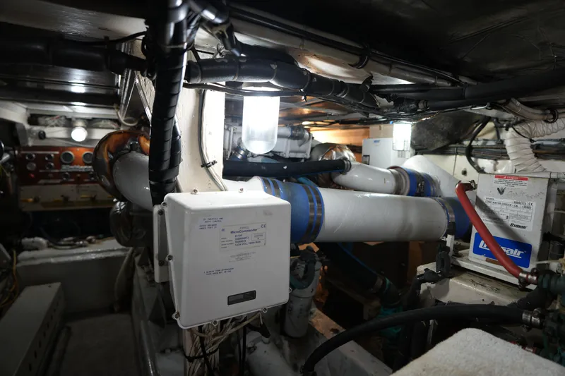 Slide: The Image of Engine room of a 1980 Hatteras 50 Convertible yacht, showcasing mechanical components and wiring. - 64