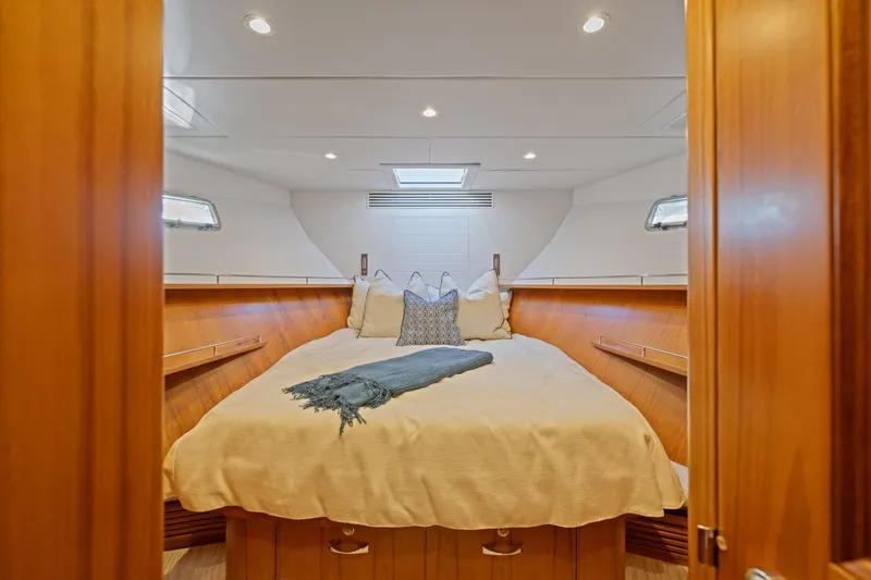 Slide: The Image of Luxurious cabin interior of 2023 Offshore Yachts 64 ELV with cozy bedding and elegant wood finish. - 25