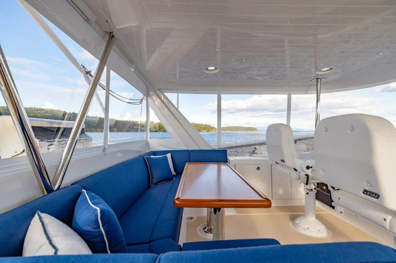 Slide: The Image of Luxurious seating area on 2023 Offshore Yachts 64 ELV, featuring blue cushions and scenic views. - 38