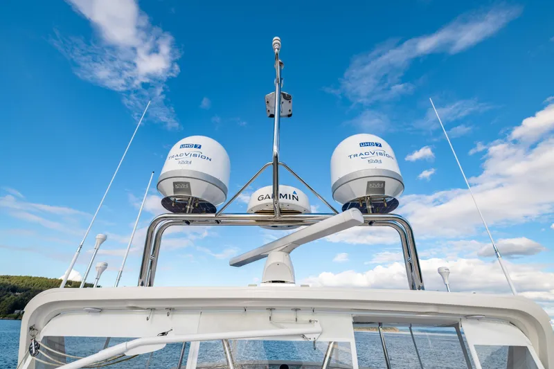 Slide: The Image of 2023 Offshore Yachts 64 ELV with advanced radar and satellite equipment against a clear blue sky. - 42