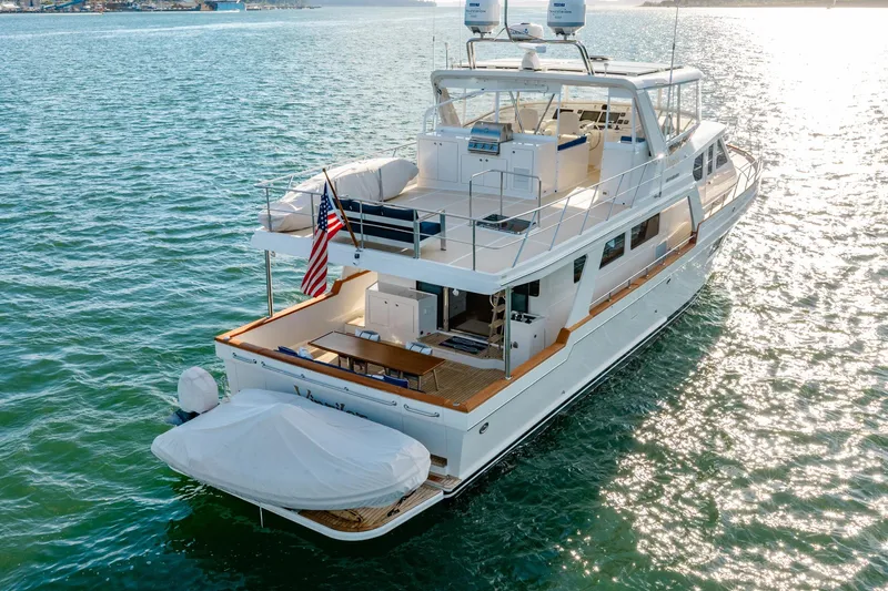 Slide: The Image of 2023 Offshore Yachts 64 ELV cruising on sunlit waters, showcasing elegant design and spacious deck. - 43