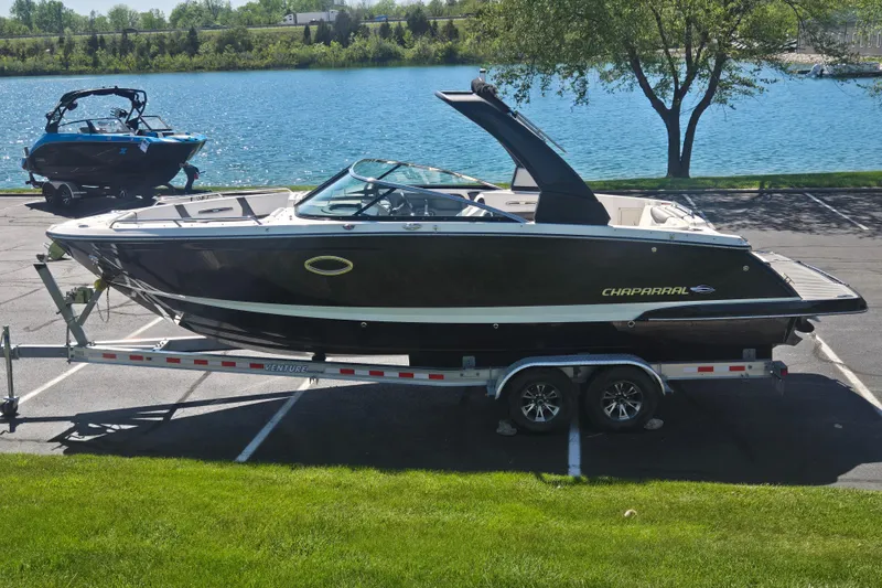 The Image of 2018 Chaparral 267 SSX boat on trailer by a scenic lake. - 0